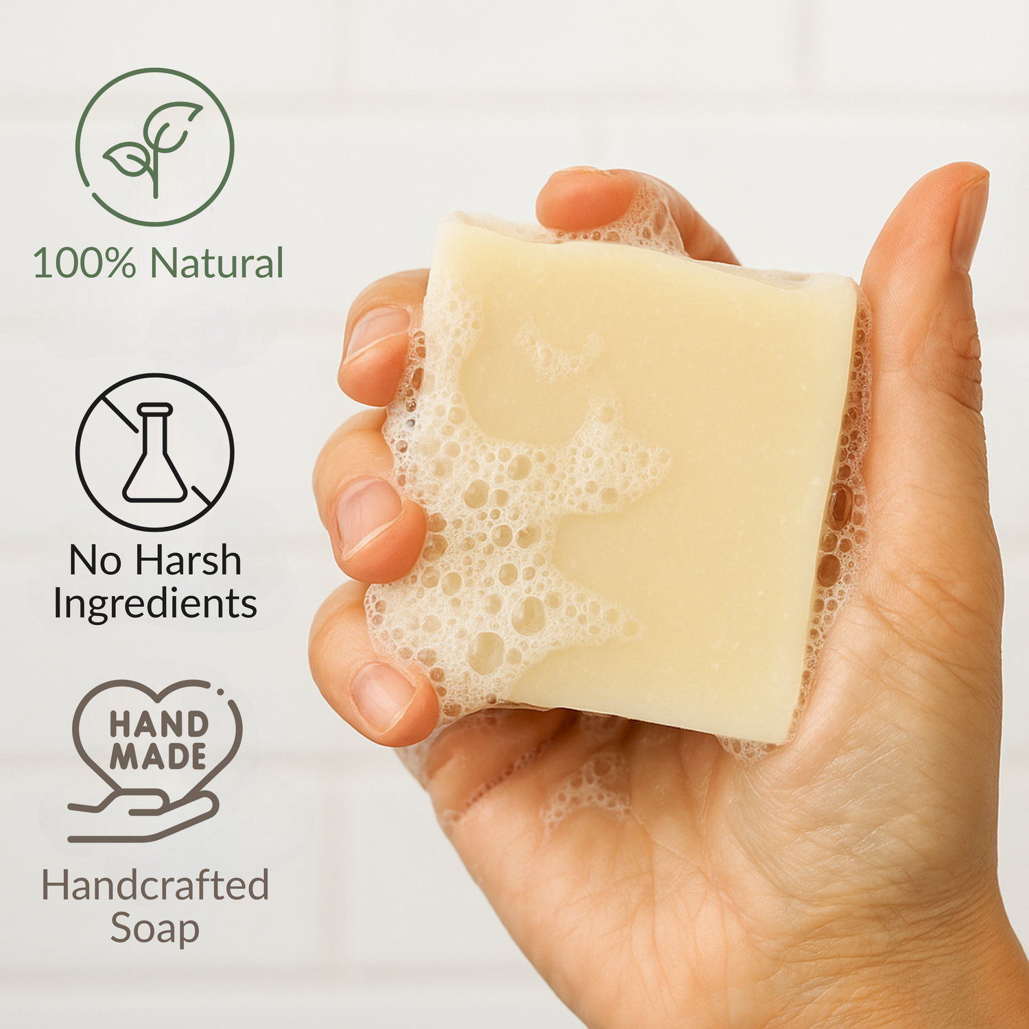 Hand holding a lathered grass fed tallow soap bar with bubbles, promoting 100% natural, handcrafted, and chemical free skincare.
